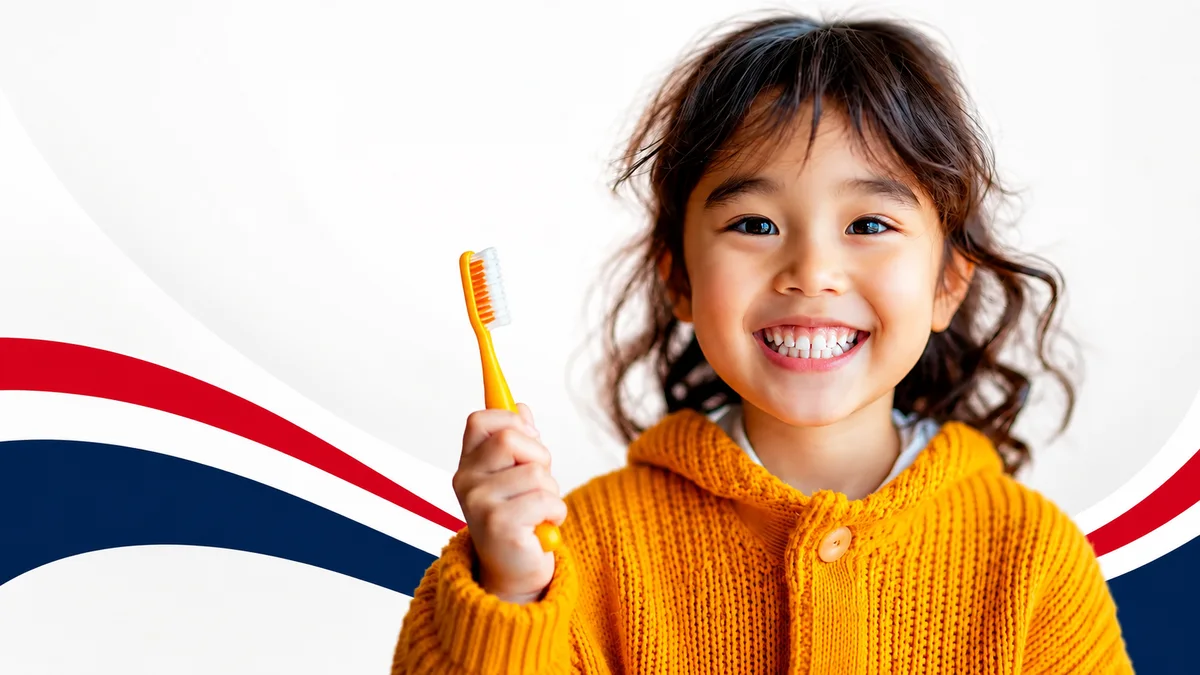 A smiling child holding a toothbrush at Dental Group of Aurora